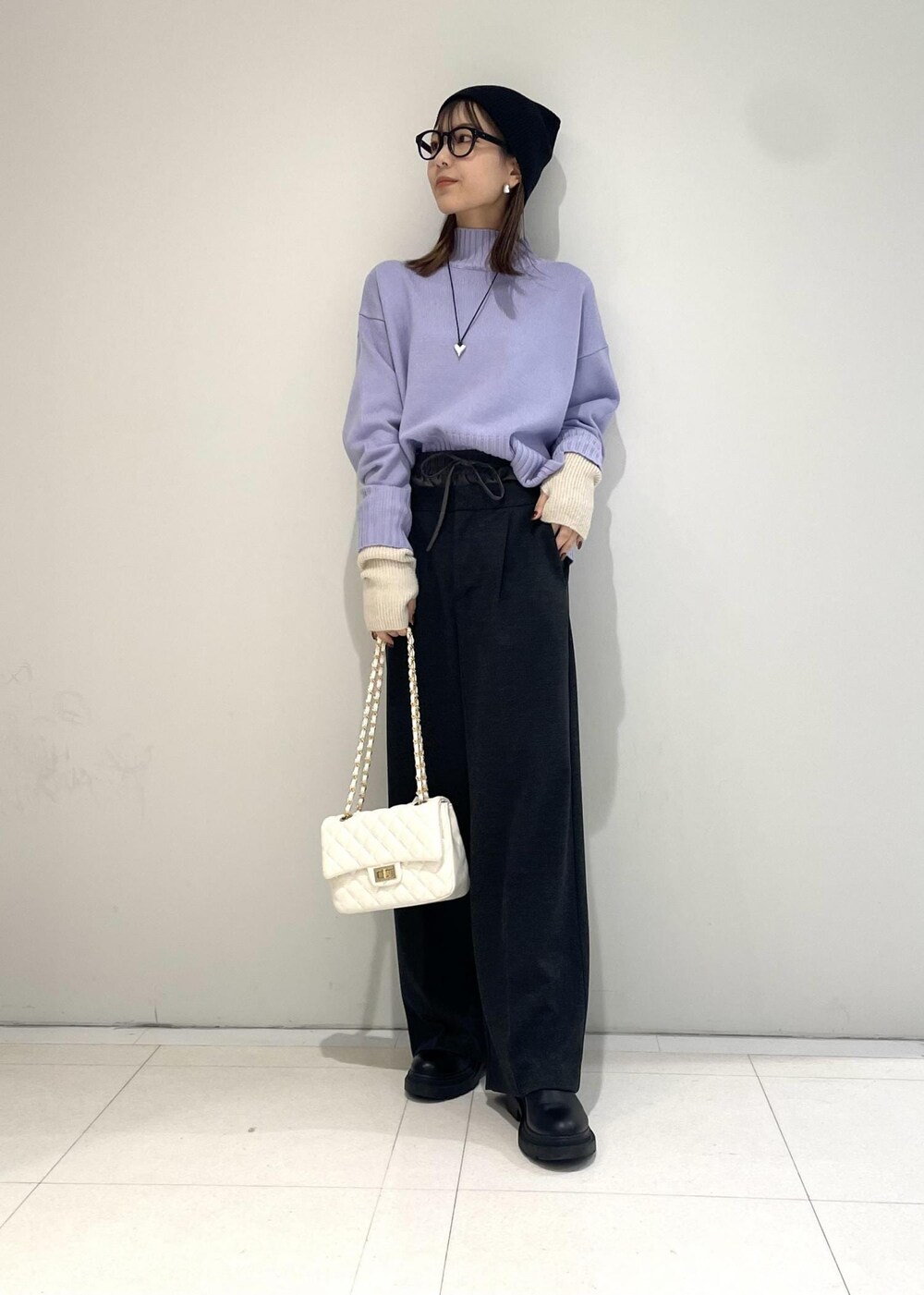 ホワイト系のショルダーバッグ、パープル系のニット/セーター、グレー系のスラックスを着用したレディースの秋コーディネートの2枚目の写真
