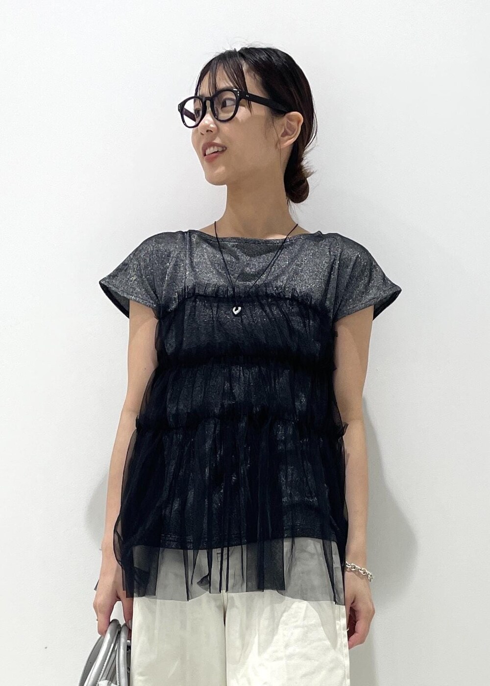 シルバー系のショルダーバッグ、ブラック系のサンダル、ブラック系のTシャツ/カットソーを着用したレディースの夏コーディネートの3枚目の写真