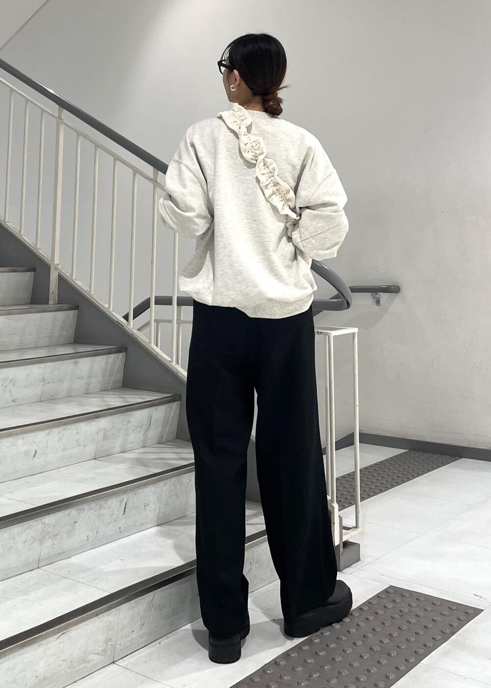ブラック系のブーツ、ホワイト系のショルダーバッグ、ホワイト系のスウェットを着用したレディースの秋コーディネートの4枚目の写真