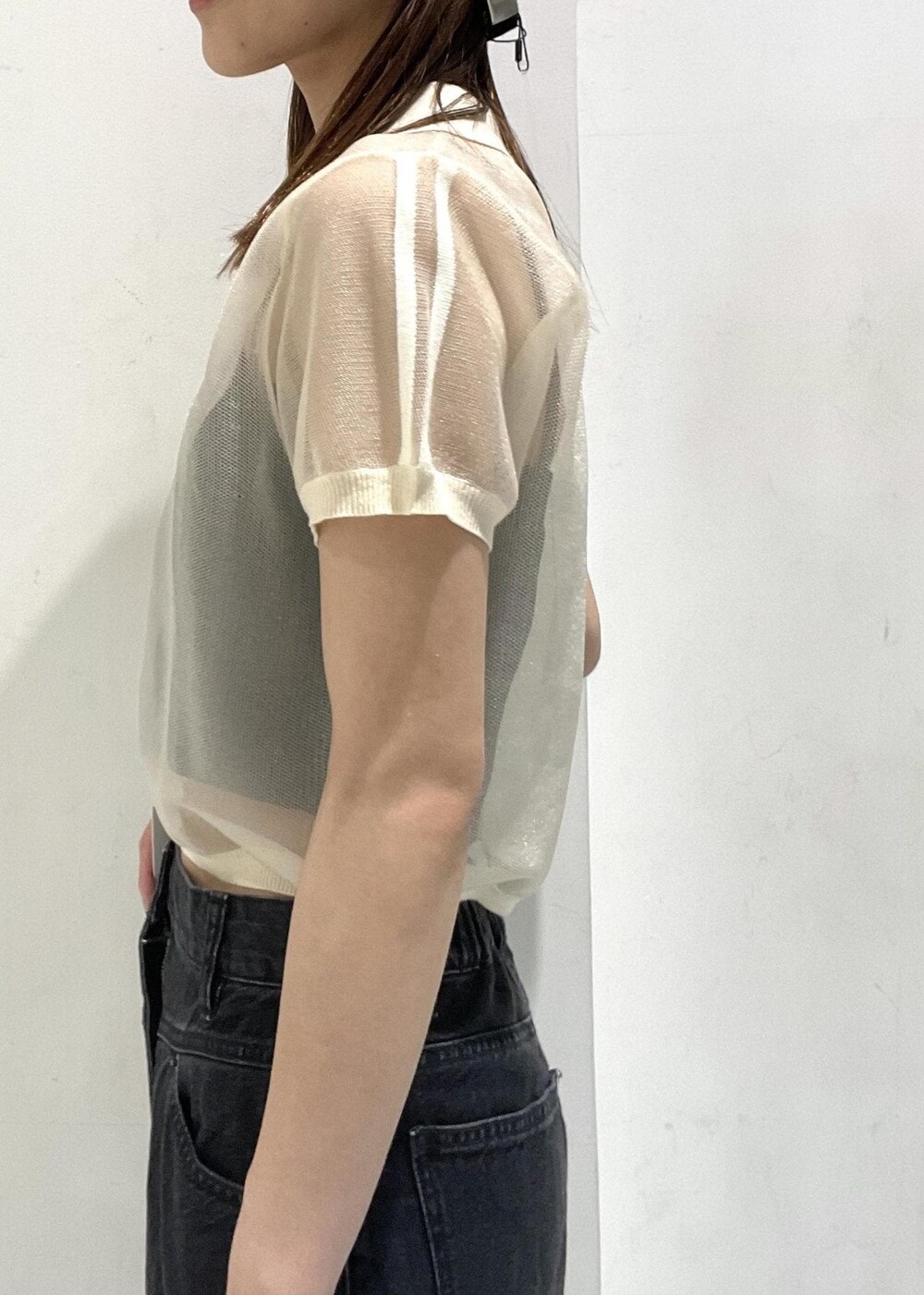 シルバー系のショルダーバッグ、ブラック系のデニムパンツ、ホワイト系のポロシャツを着用したレディースの夏コーディネートの8枚目の写真