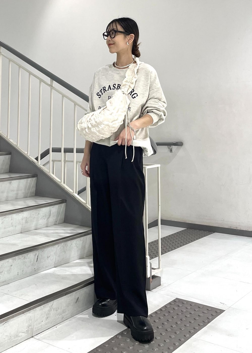 ブラック系のブーツ、ホワイト系のショルダーバッグ、ホワイト系のスウェットを着用したレディースの秋コーディネートの2枚目の写真