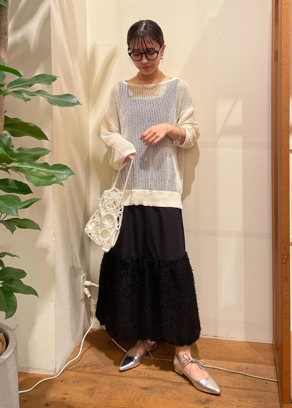 シルバー系のパンプス、ホワイト系のハンドバッグ、ホワイト系のニット/セーターを着用したレディースの夏コーディネートの3枚目の写真