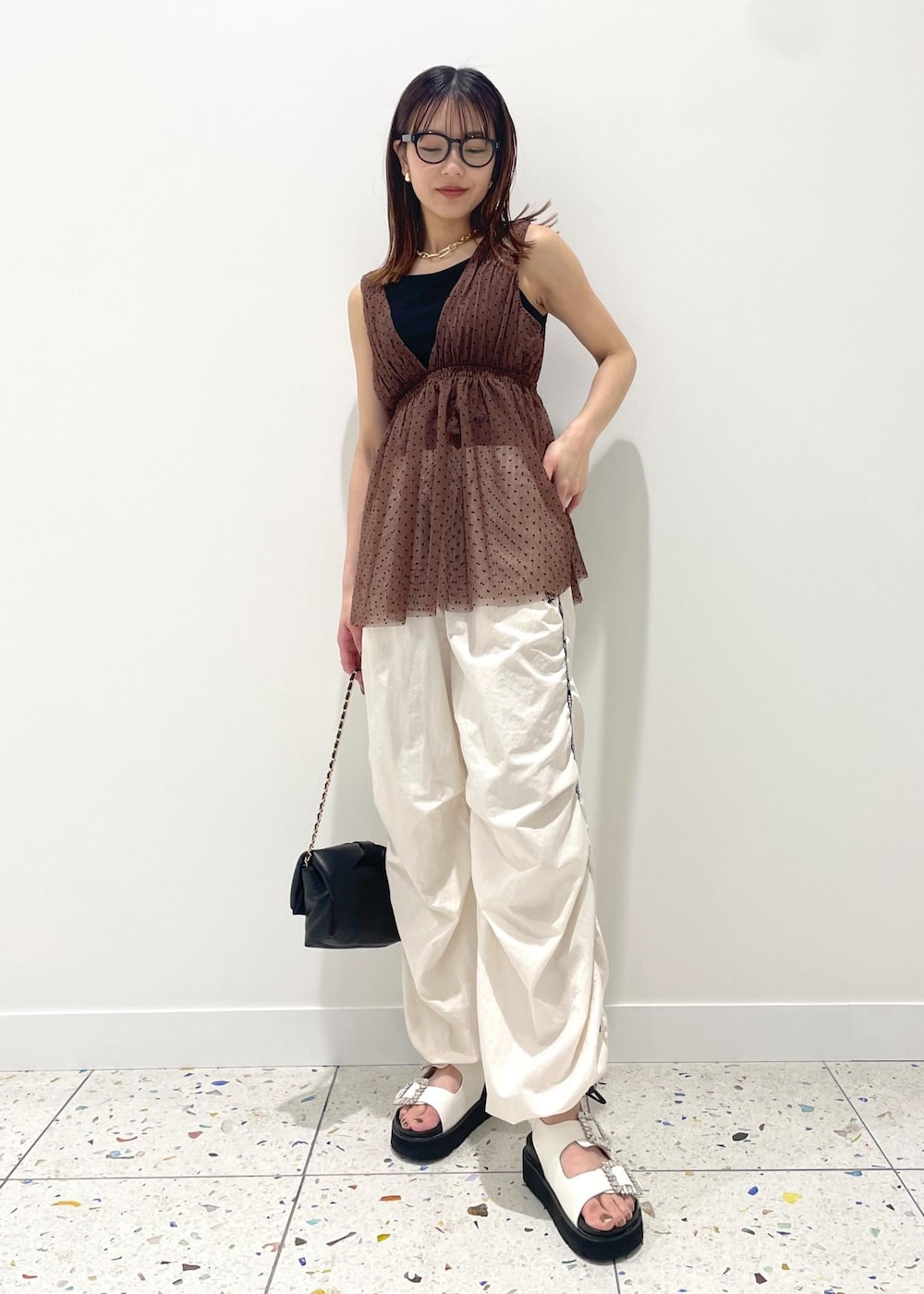 ブラック系のショルダーバッグ、ホワイト系のその他パンツ、ホワイト系のサンダルを着用したレディースの春コーディネートの2枚目の写真