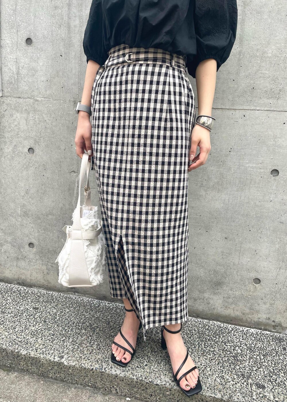 ブラック系のサンダル、ブラック系のスカート、ブラック系のシャツ/ブラウスを着用したレディースの春コーディネートの2枚目の写真