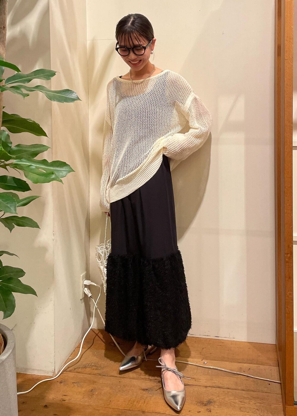 シルバー系のパンプス、ホワイト系のハンドバッグ、ホワイト系のニット/セーターを着用したレディースの夏コーディネートの4枚目の写真