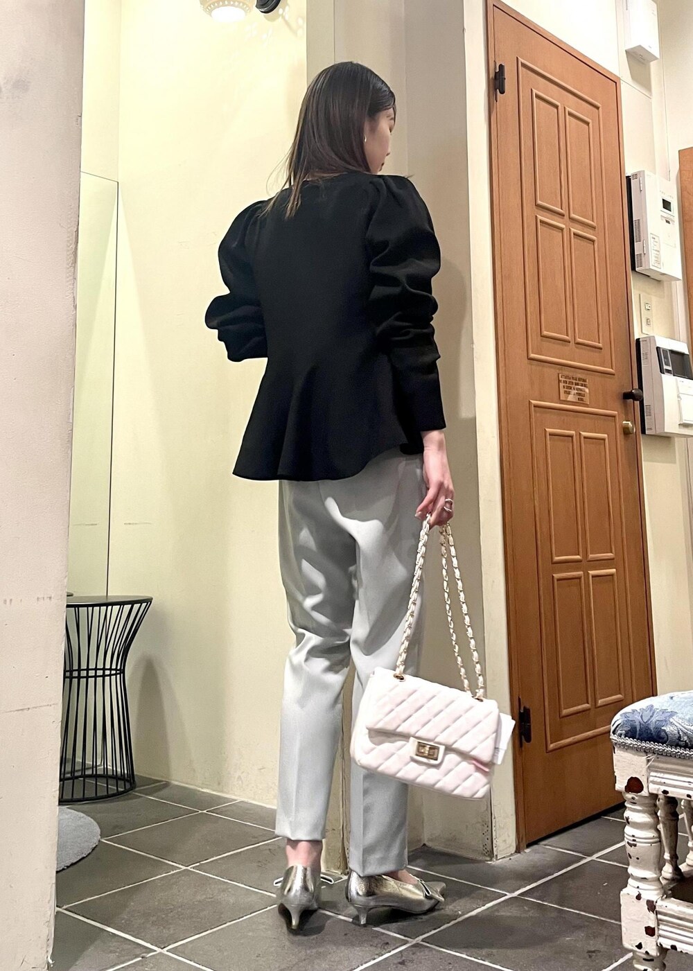ホワイト系のショルダーバッグ、ブラック系のニット/セーター、シルバー系のパンプスを着用したレディースの冬コーディネートの4枚目の写真
