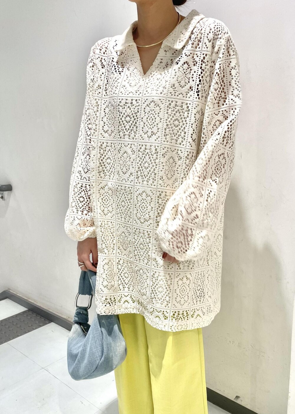 シルバー系のパンプス、イエロー系のスラックス、ブルー系のハンドバッグを着用したレディースの春コーディネートの3枚目の写真