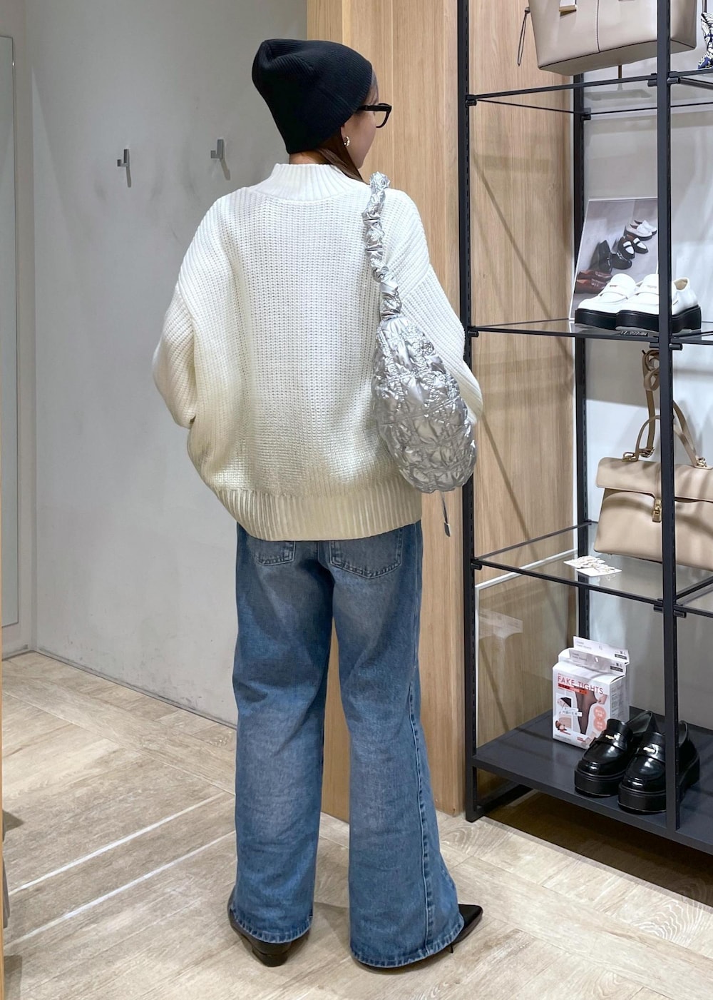 ホワイト系のニット/セーター、ブルー系のデニムパンツ、ブラック系のパンプスを着用したレディースの冬コーディネートの3枚目の写真