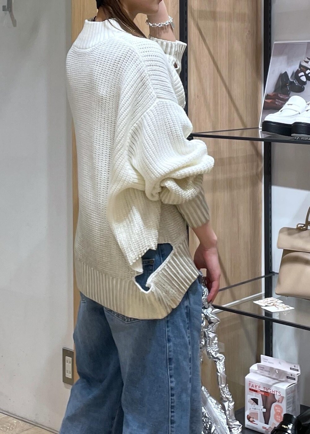 ホワイト系のニット/セーター、ブルー系のデニムパンツ、ブラック系のパンプスを着用したレディースの冬コーディネートの4枚目の写真