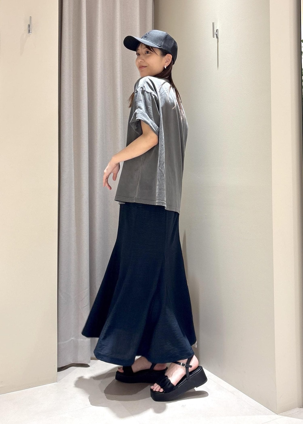 ホワイト系のハンドバッグ、ブルー系のスカート、グレー系のTシャツ/カットソーを着用したレディースの春コーディネートの2枚目の写真