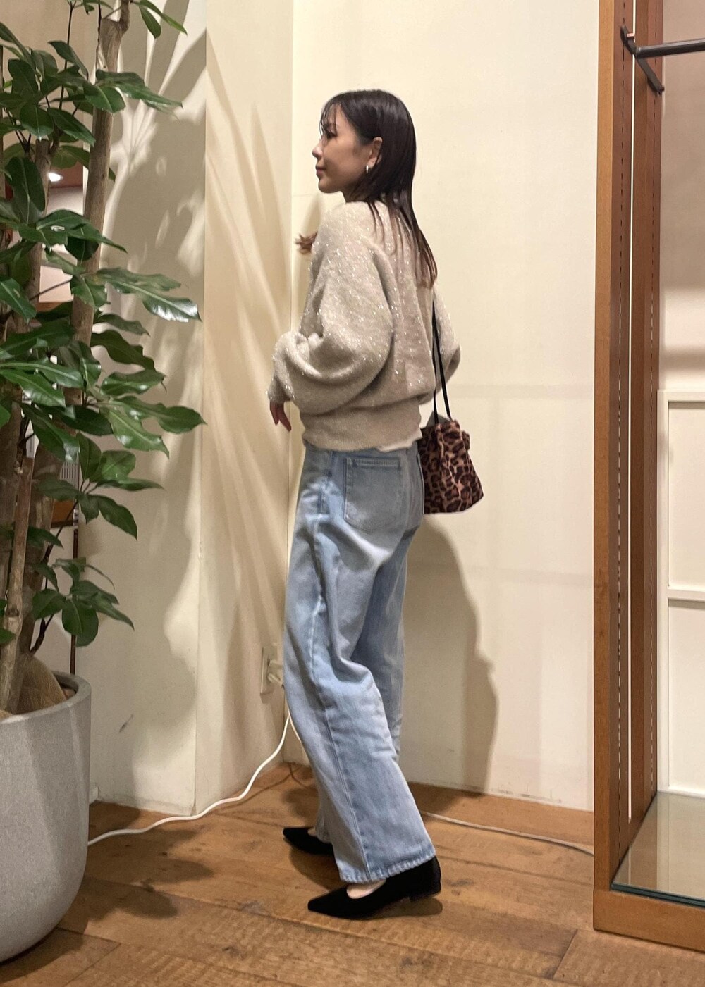 ベージュ系のニット/セーター、ホワイト系のTシャツ/カットソー、ブルー系のデニムパンツを着用したレディースの冬コーディネートの2枚目の写真