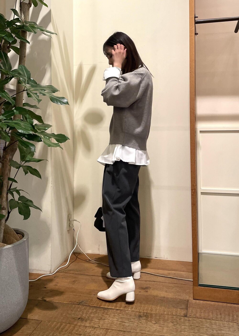 ホワイト系のブーツ、ホワイト系のシャツ/ブラウス、グレー系のニット/セーターを着用したレディースの秋コーディネートの4枚目の写真
