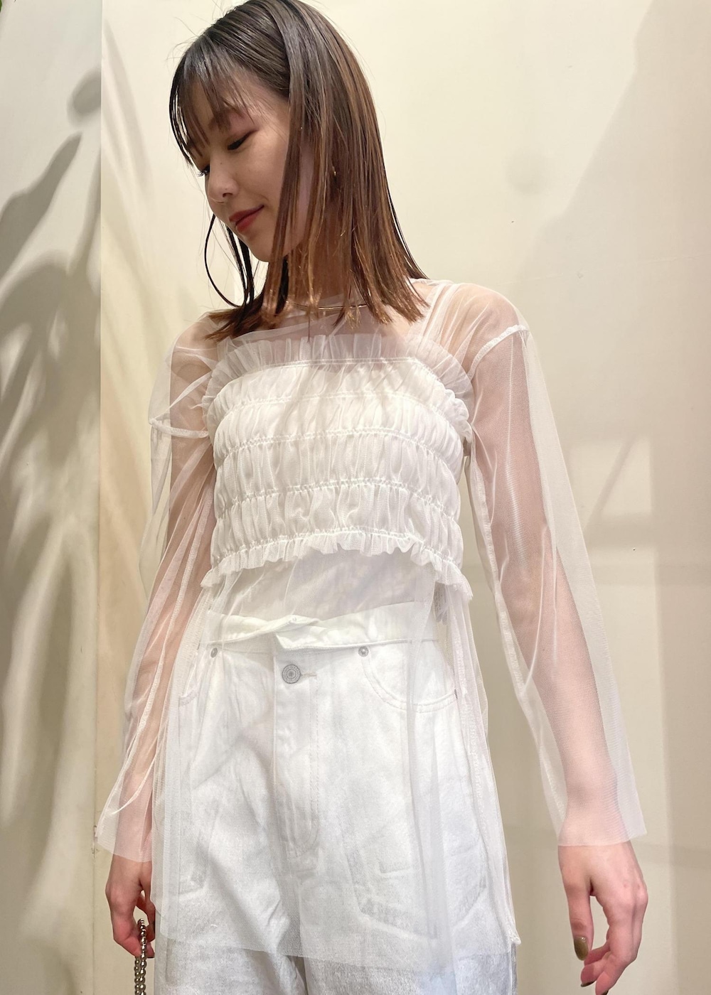 ホワイト系のデニムパンツ、シルバー系のハンドバッグ、ホワイト系のTシャツ/カットソーを着用したレディースの春コーディネートの2枚目の写真