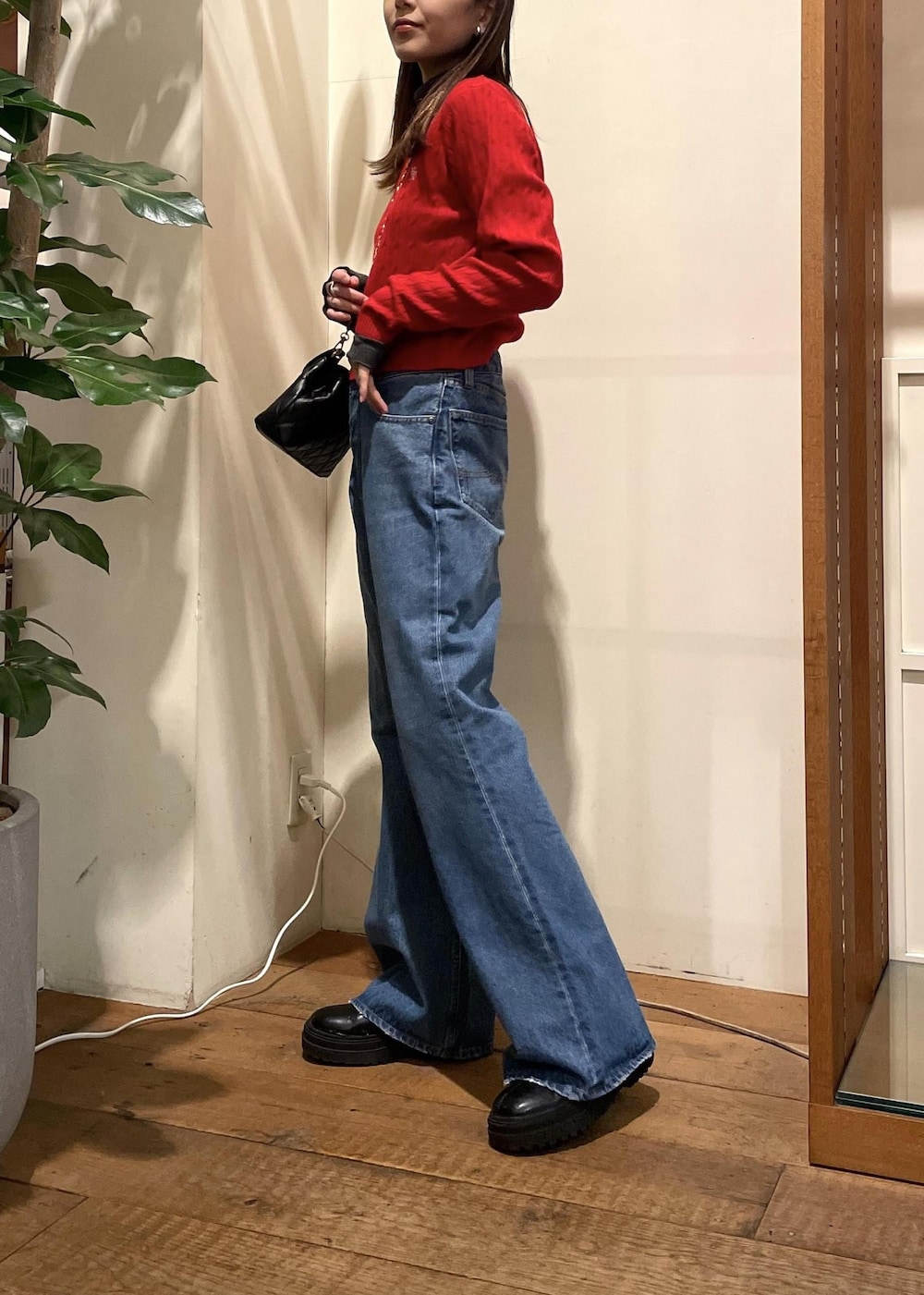 ブルー系のデニムパンツ、ブラック系のブーツ、グレー系のTシャツ/カットソーを着用したレディースの冬コーディネートの2枚目の写真