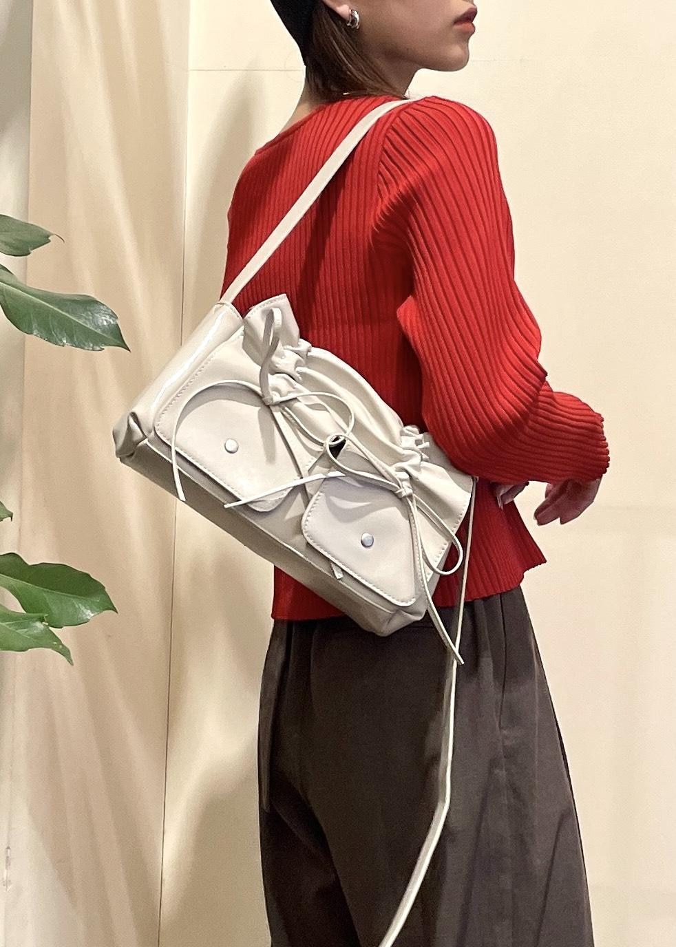 ブラック系のキャミソール、ブラック系のブーツ、レッド系のカーディガン/ボレロを着用したレディースの秋コーディネートの7枚目の写真