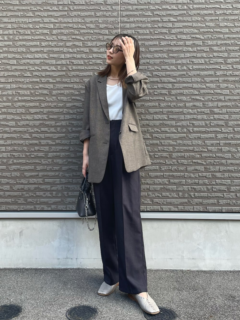 ブラック系のパンツ、グレー系のパンプス、ホワイト系のTシャツ/カットソーを着用したレディースの冬コーディネートの2枚目の写真