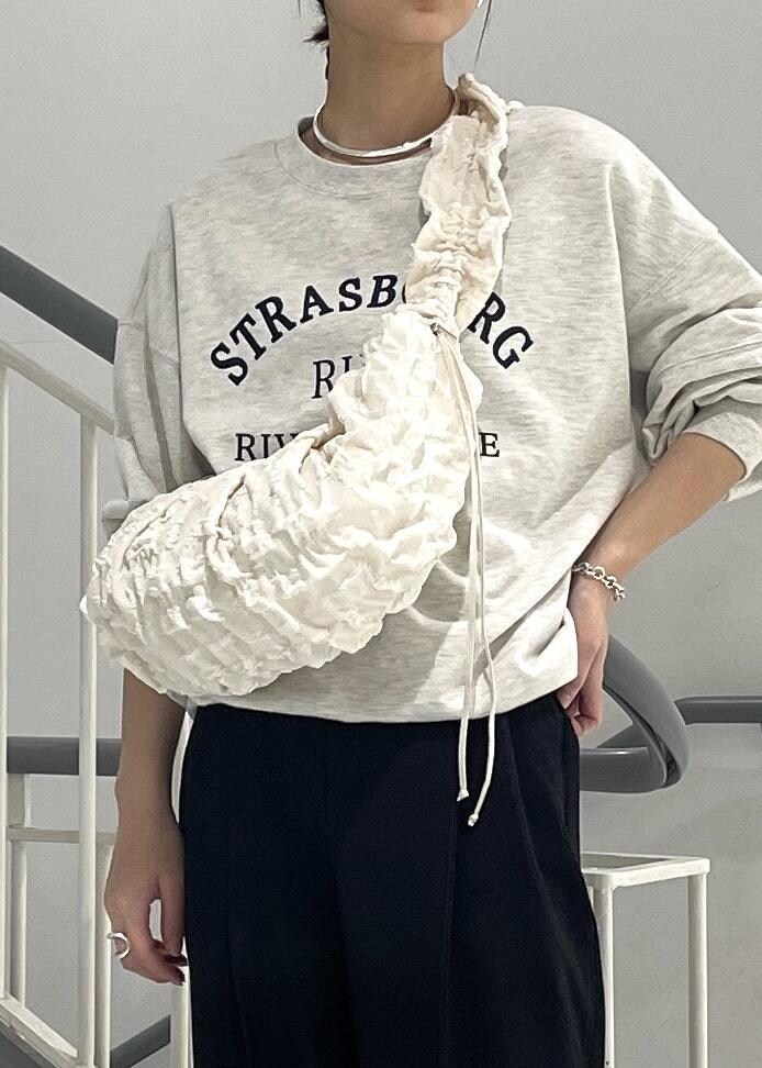 ブラック系のブーツ、ホワイト系のショルダーバッグ、ホワイト系のスウェットを着用したレディースの秋コーディネートの6枚目の写真