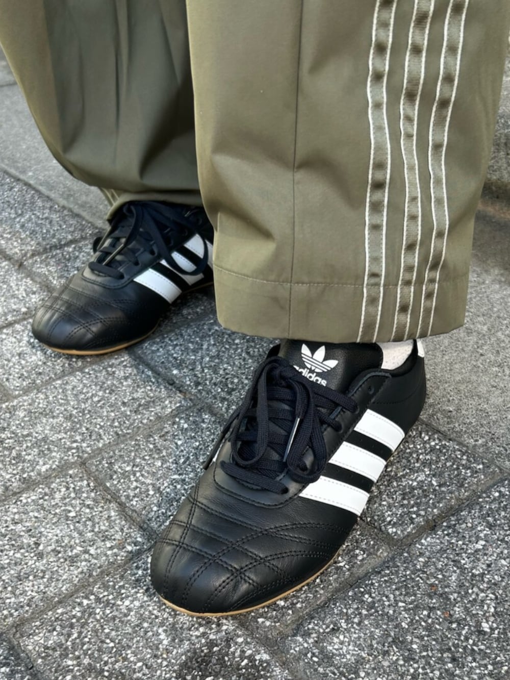 ブラック系のジャージ、グリーン系のカーゴパンツ、ブラック系のスニーカーを着用したレディースの春コーディネートの4枚目の写真