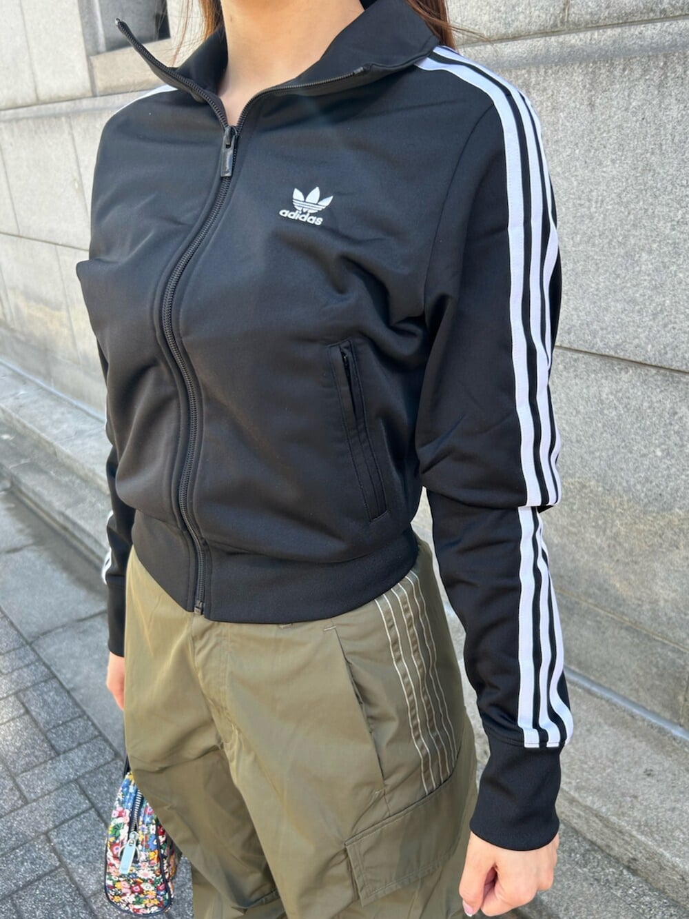 ブラック系のジャージ、グリーン系のカーゴパンツ、ブラック系のスニーカーを着用したレディースの春コーディネートの2枚目の写真