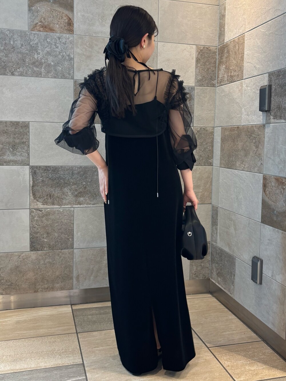 ブラック系のワンピース、ブラック系のパンプス、ブラック系のショルダーバッグを着用したレディースの夏コーディネートの3枚目の写真