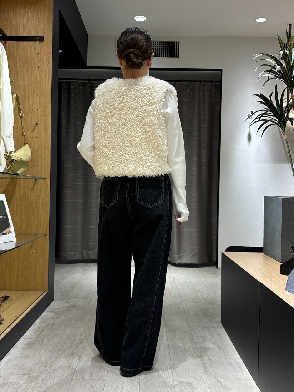 ブラック系のデニムパンツ、ホワイト系のジャケット/アウター、ホワイト系のニット/セーターを着用したレディースの秋コーディネートの2枚目の写真