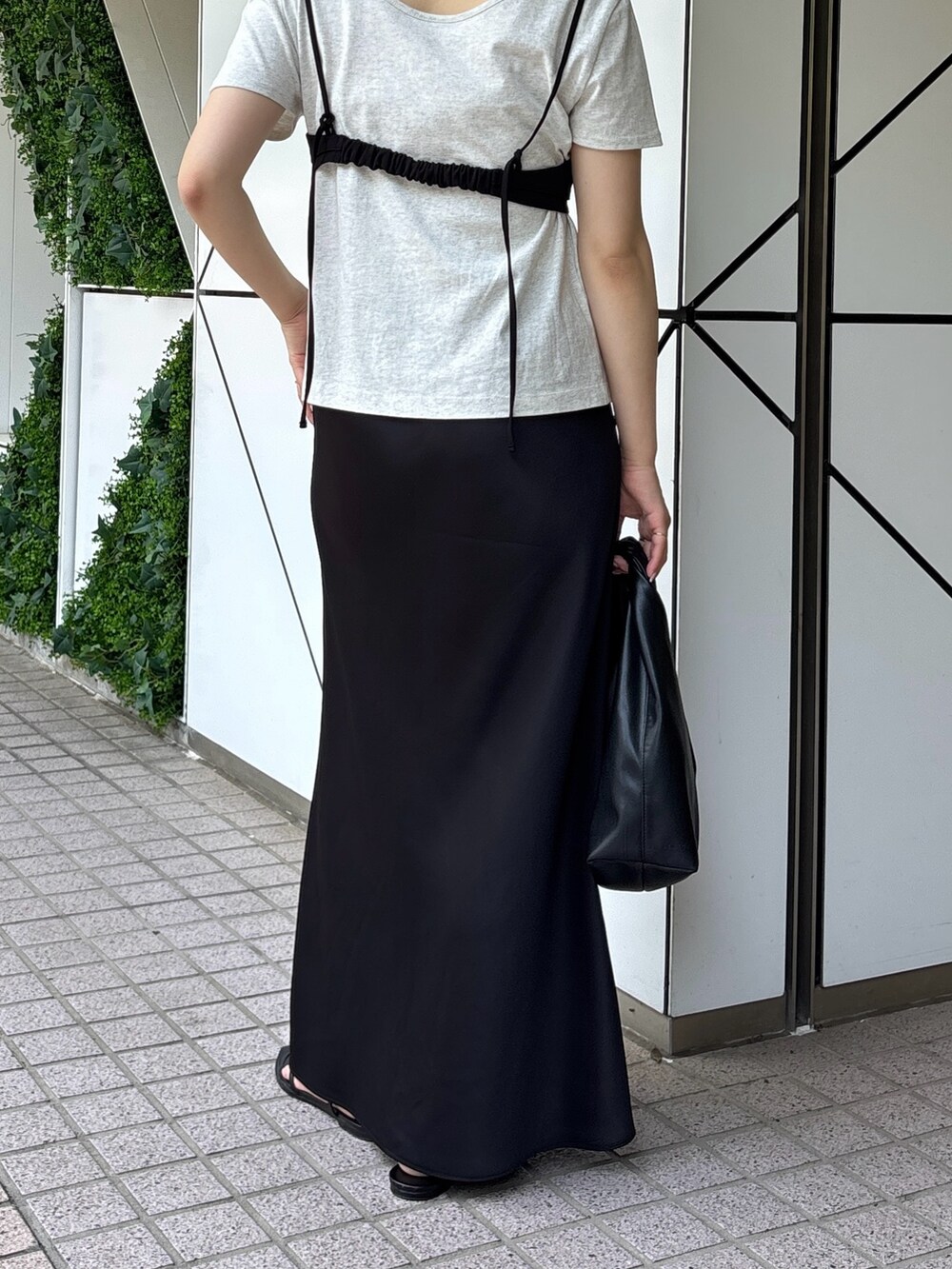 ブラック系のスカート、シルバー系のTシャツ/カットソー、ブラック系のサンダルを着用したレディースの春コーディネートの3枚目の写真