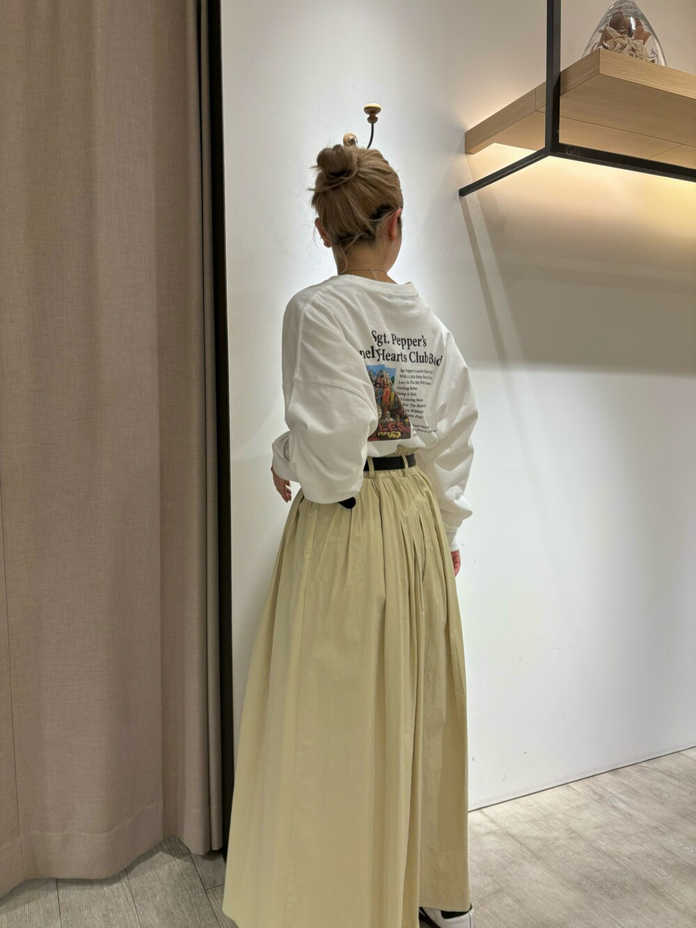 イエロー系のスカート、ホワイト系のTシャツ/カットソー、シルバー系のネックレスを着用したレディースの冬コーディネートの4枚目の写真