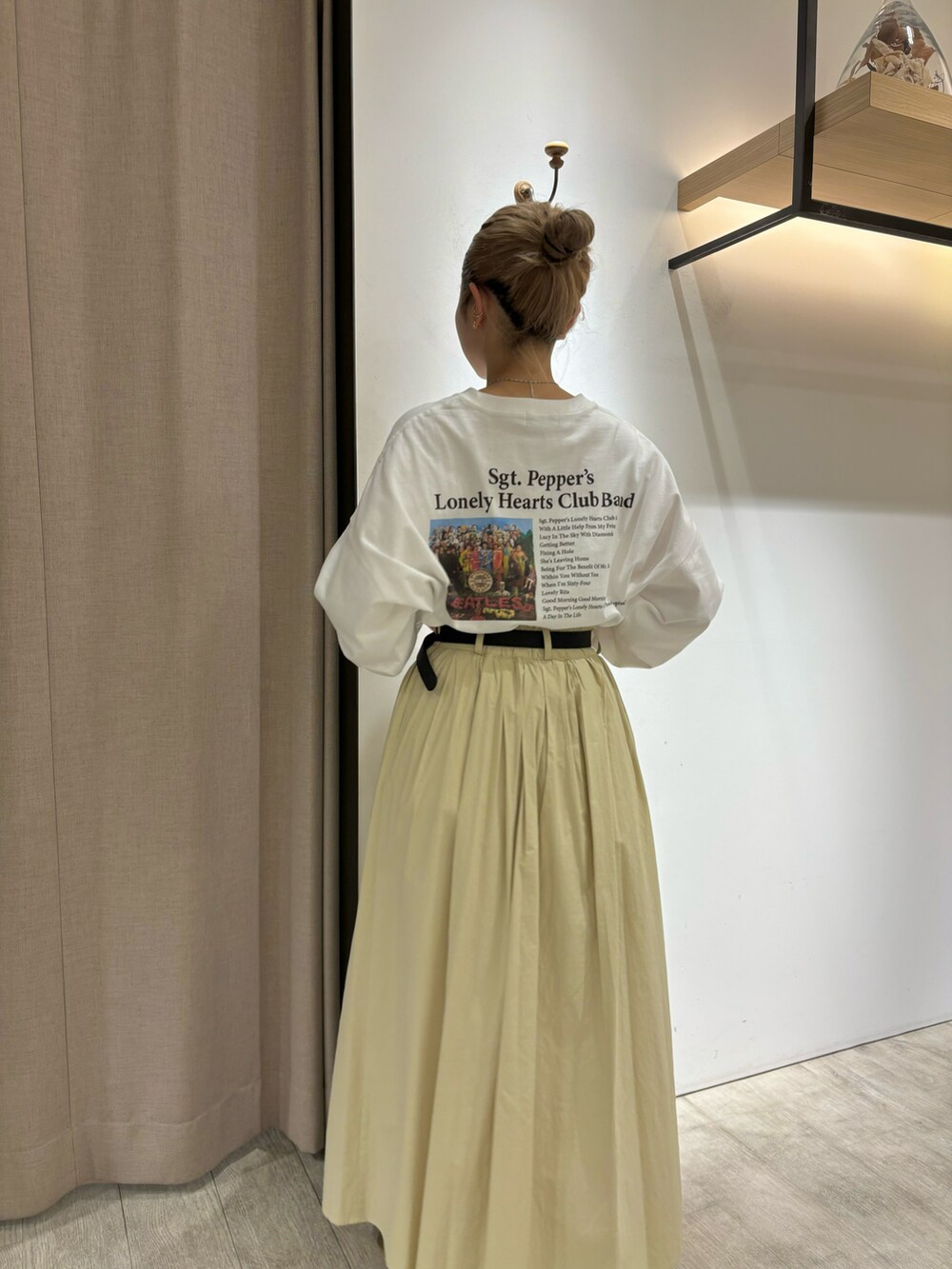 イエロー系のスカート、ホワイト系のTシャツ/カットソー、シルバー系のネックレスを着用したレディースの冬コーディネートの2枚目の写真