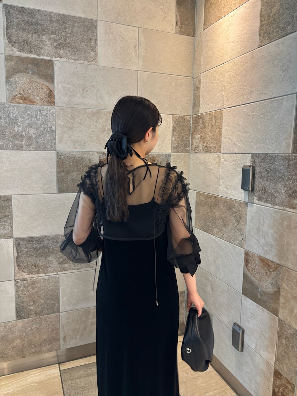 ブラック系のワンピース、ブラック系のパンプス、ブラック系のショルダーバッグを着用したレディースの夏コーディネートの4枚目の写真