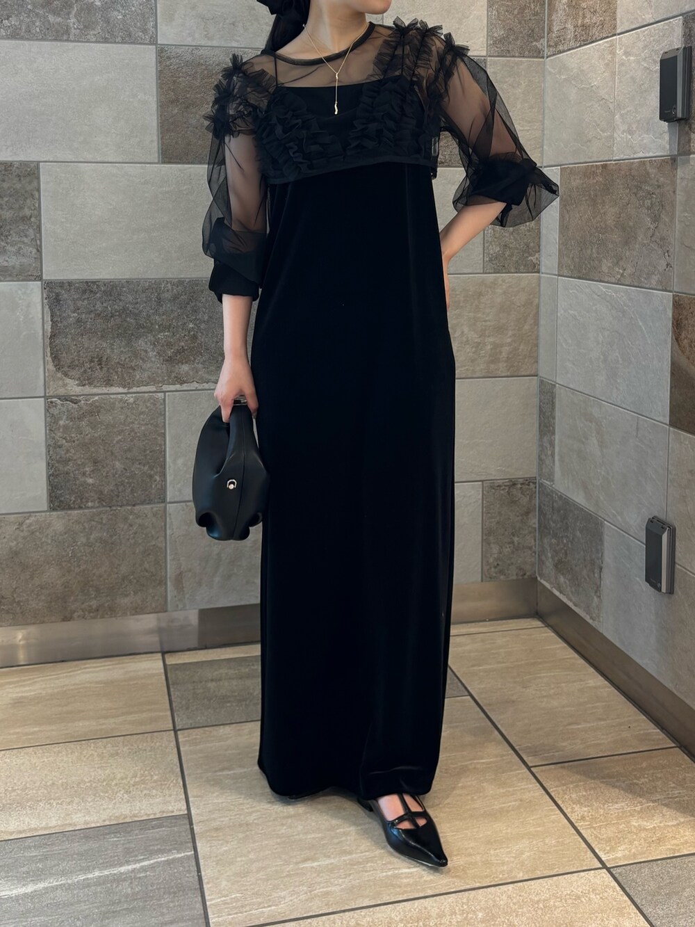 ブラック系のワンピース、ブラック系のパンプス、ブラック系のショルダーバッグを着用したレディースの夏コーディネートの2枚目の写真