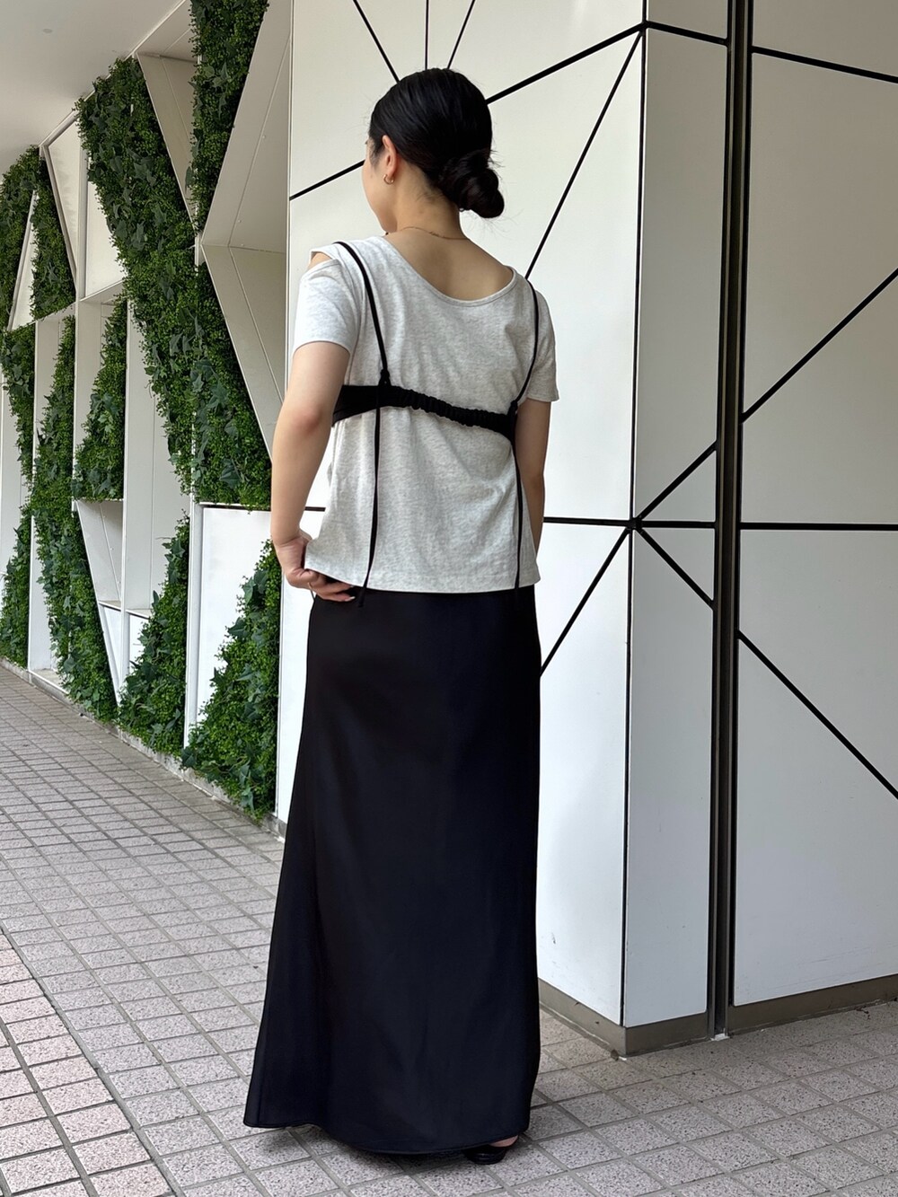 ブラック系のスカート、シルバー系のTシャツ/カットソー、ブラック系のサンダルを着用したレディースの春コーディネートの2枚目の写真