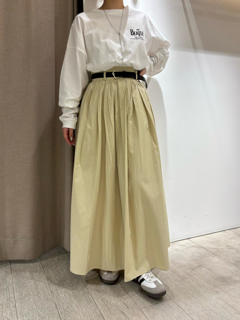 イエロー系のスカート、ホワイト系のTシャツ/カットソー、シルバー系のネックレスを着用したレディースの冬コーディネートの5枚目の写真