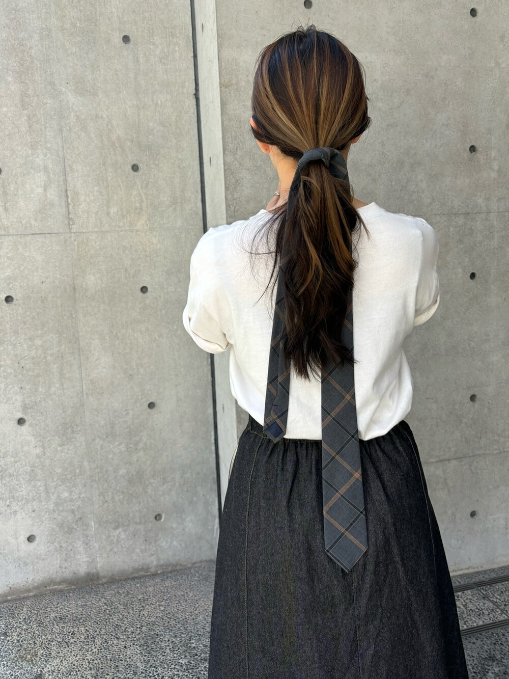 ホワイト系のTシャツ/カットソー、ブラック系のデニムスカートを着用したレディースの春コーディネートの2枚目の写真