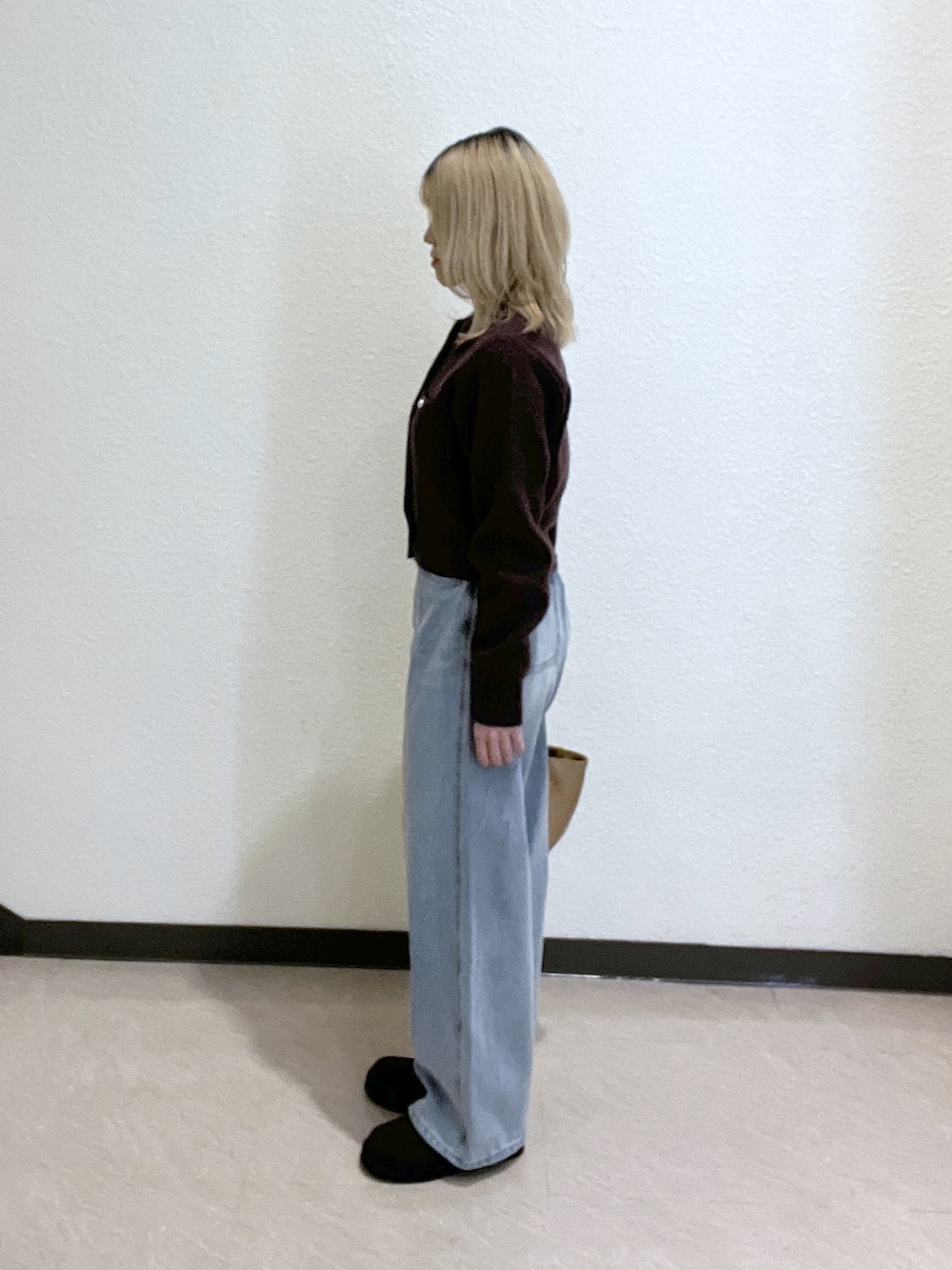 ブラウン系のニット/セーター、ベージュ系のトートバッグ、ブルー系のデニムパンツを着用したレディースの秋コーディネートの5枚目の写真