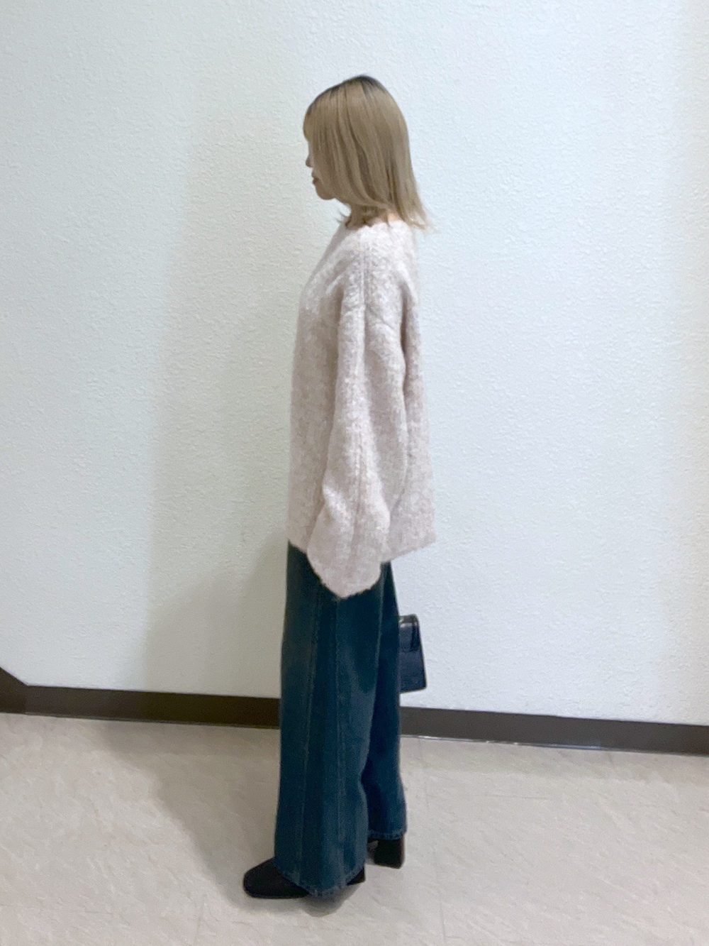 ブルー系のデニムパンツ、ブラック系のショルダーバッグ、ピンク系のニット/セーターを着用したレディースの秋コーディネートの4枚目の写真