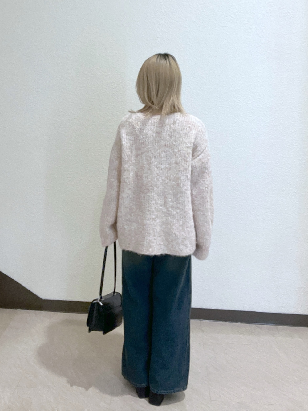 ブルー系のデニムパンツ、ブラック系のショルダーバッグ、ピンク系のニット/セーターを着用したレディースの秋コーディネートの3枚目の写真