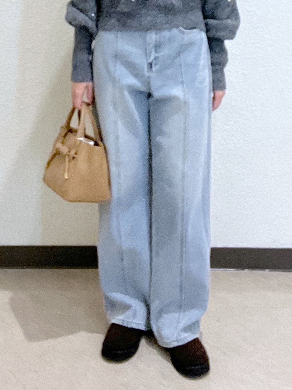 グレー系のニット/セーター、ブルー系のデニムパンツ、ベージュ系のトートバッグを着用したレディースの秋コーディネートの7枚目の写真