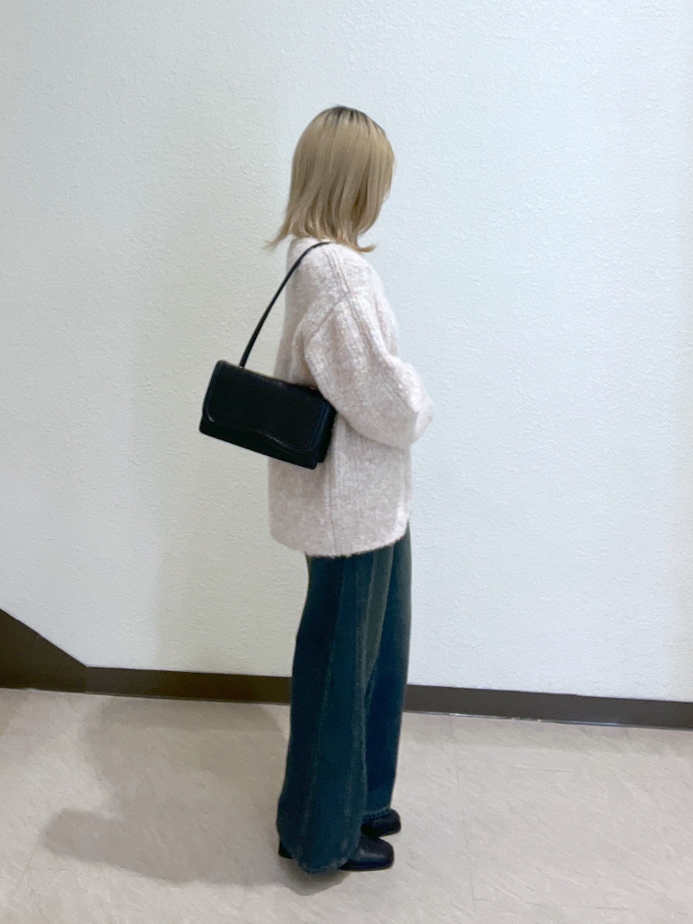 ブルー系のデニムパンツ、ブラック系のショルダーバッグ、ピンク系のニット/セーターを着用したレディースの秋コーディネートの2枚目の写真