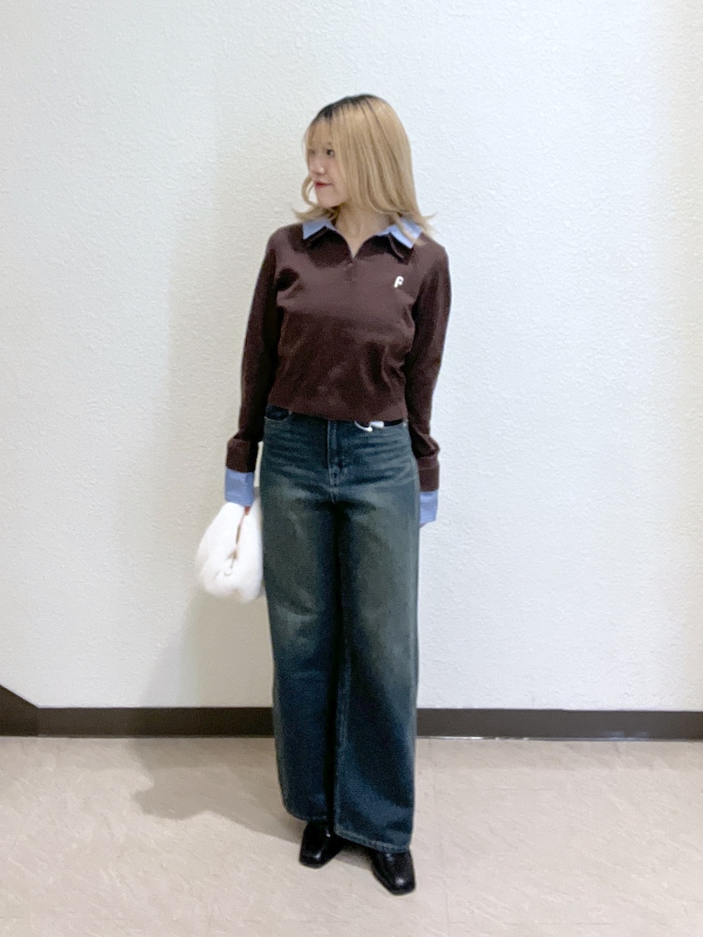 ブラウン系のニット/セーター、ブラック系のブーツ、ブルー系のデニムパンツを着用したレディースの秋コーディネートの2枚目の写真