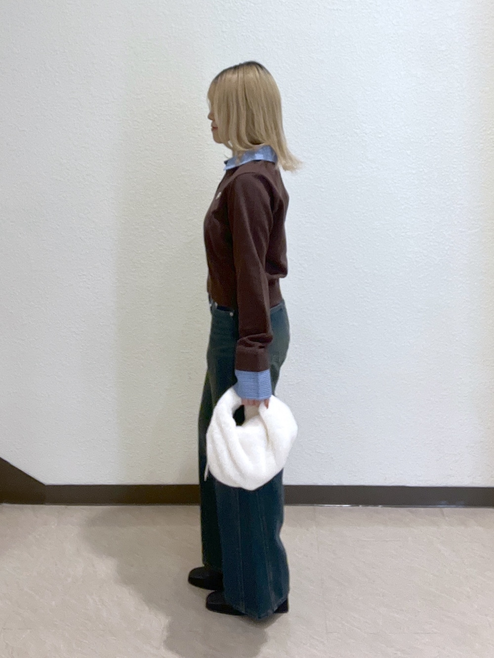 ブラウン系のニット/セーター、ブラック系のブーツ、ブルー系のデニムパンツを着用したレディースの秋コーディネートの3枚目の写真