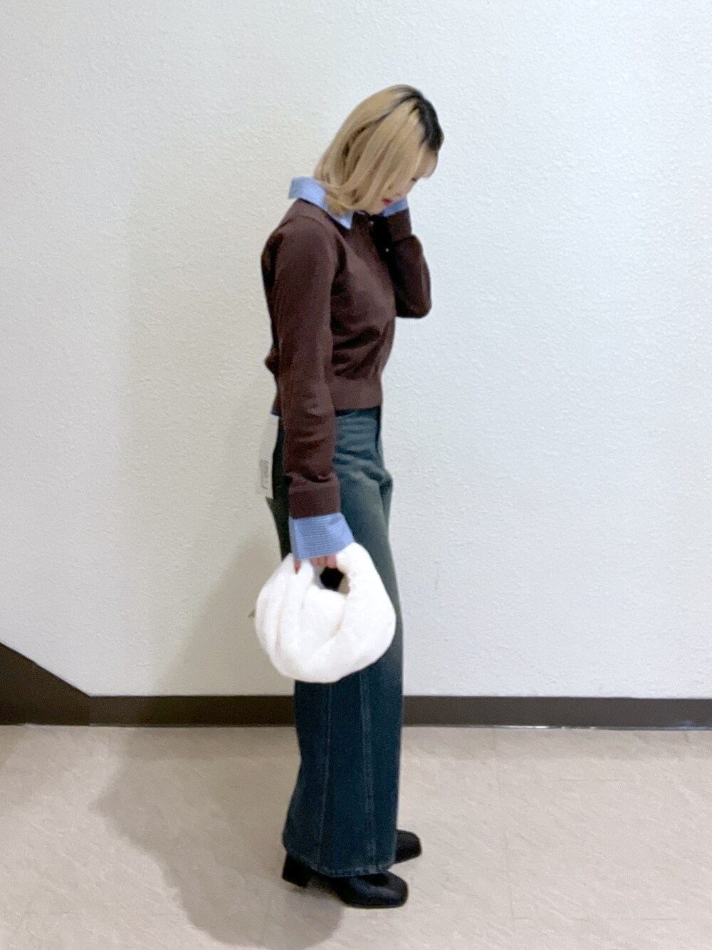 ブラウン系のニット/セーター、ブラック系のブーツ、ブルー系のデニムパンツを着用したレディースの秋コーディネートの5枚目の写真