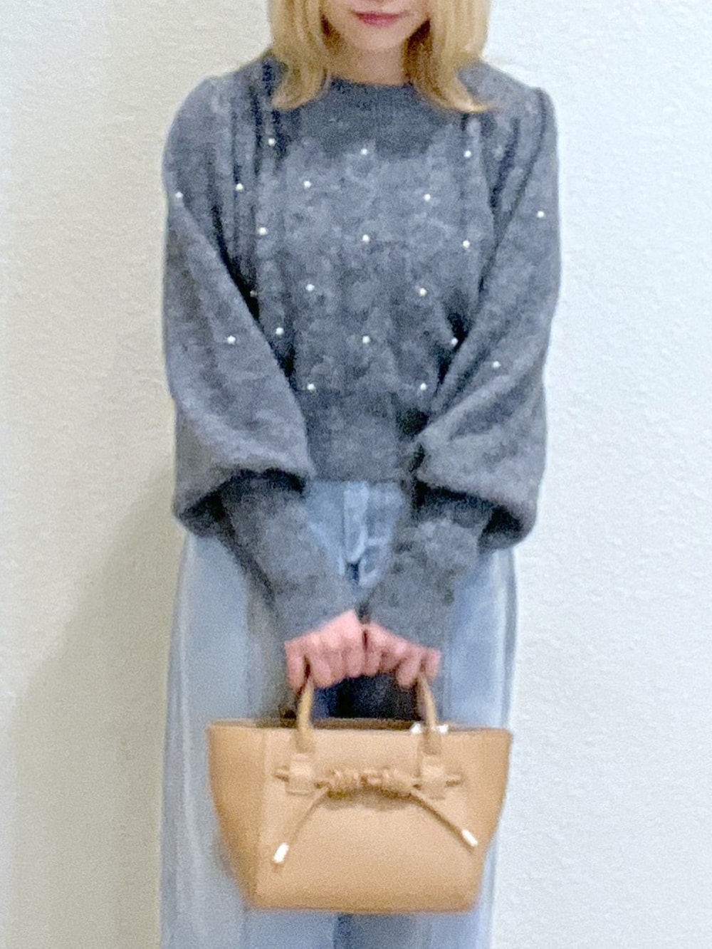 グレー系のニット/セーター、ブルー系のデニムパンツ、ベージュ系のトートバッグを着用したレディースの秋コーディネートの6枚目の写真