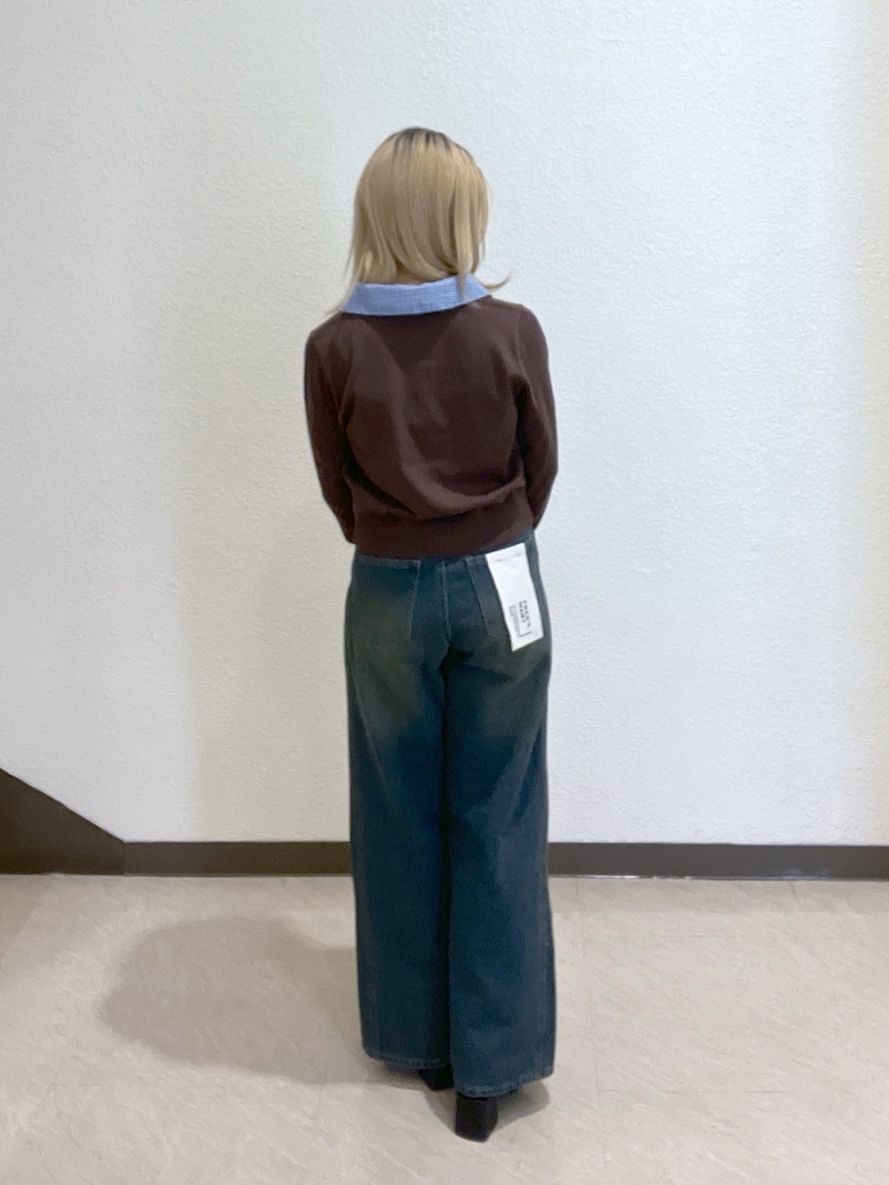 ブラウン系のニット/セーター、ブラック系のブーツ、ブルー系のデニムパンツを着用したレディースの秋コーディネートの4枚目の写真