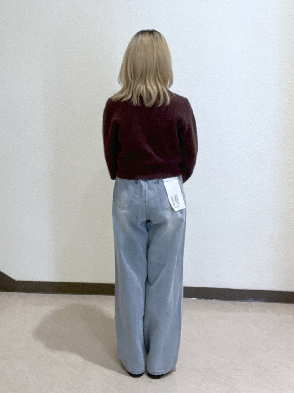 ブラウン系のニット/セーター、ベージュ系のトートバッグ、ブルー系のデニムパンツを着用したレディースの秋コーディネートの3枚目の写真