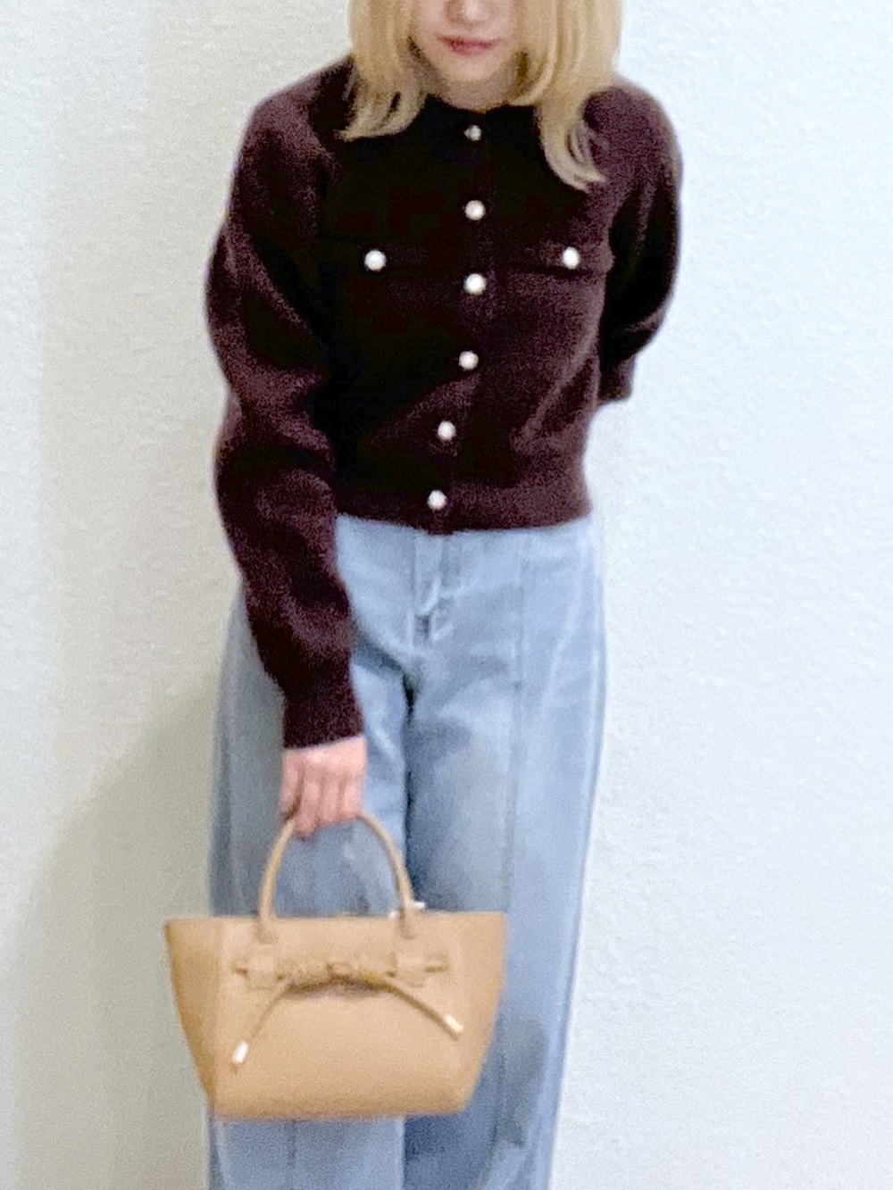 ブラウン系のニット/セーター、ベージュ系のトートバッグ、ブルー系のデニムパンツを着用したレディースの秋コーディネートの6枚目の写真