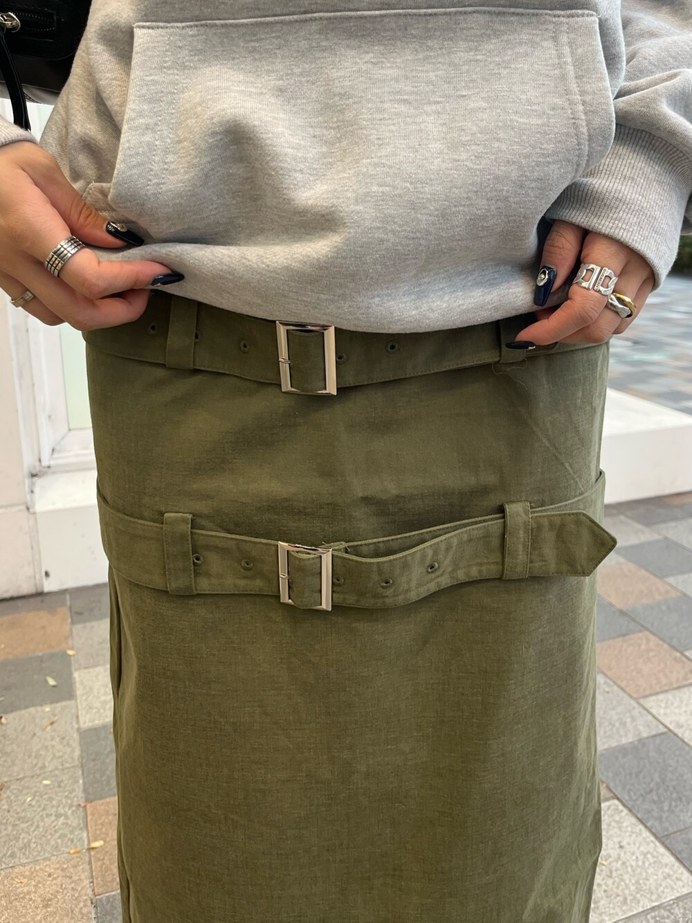 グリーン系のスカート、グレー系のパーカー、ブラック系のブーツを着用したレディースの冬コーディネートの5枚目の写真