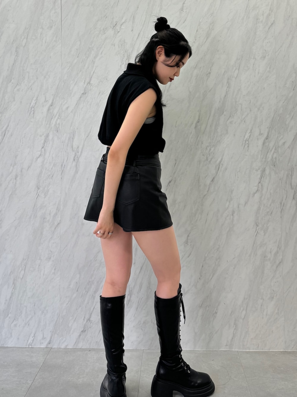 ブラック系のTシャツ/カットソー、ブラック系のスカート、ブラック系のブーツを着用したレディースの夏コーディネートの4枚目の写真