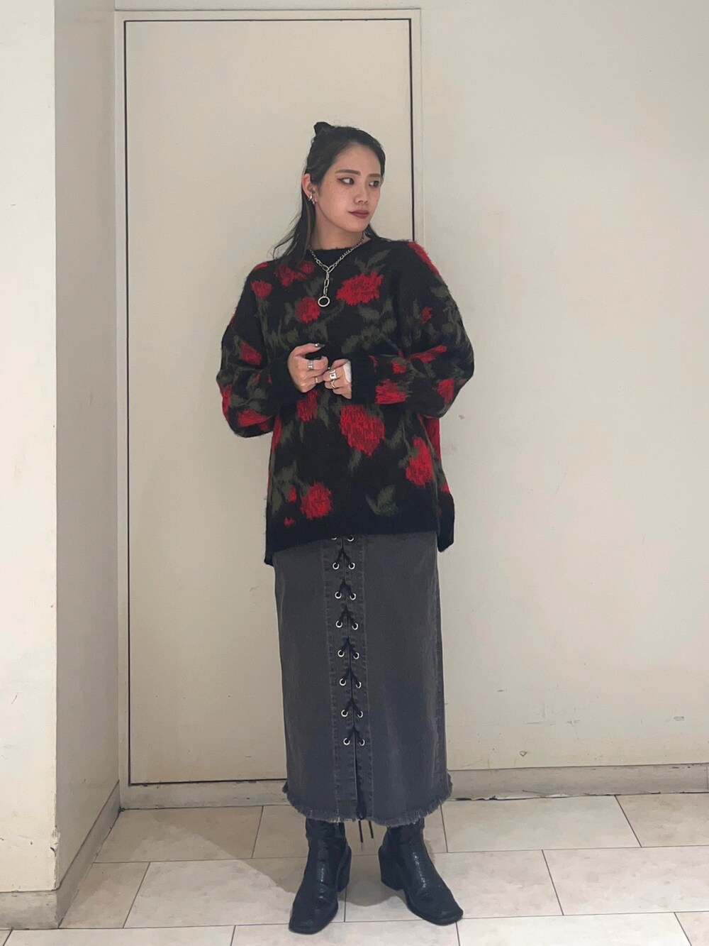 ブラック系のニット/セーター、ブラック系のデニムパンツを着用したレディースの秋コーディネートの3枚目の写真