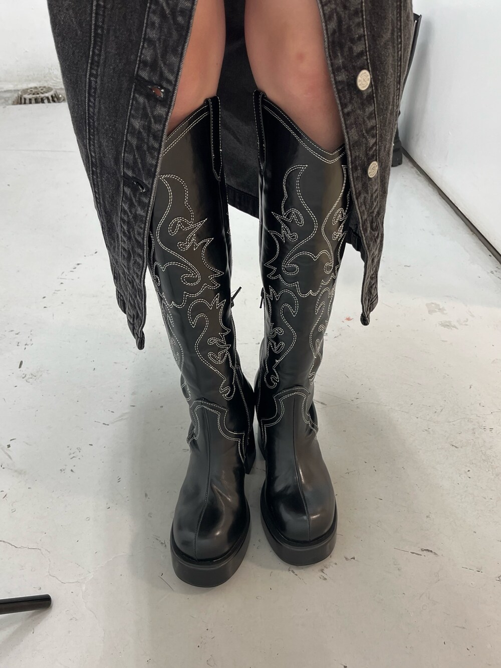 ブラック系のニット/セーター、ブラック系のワンピース、ブラック系のブーツを着用したレディースの冬コーディネートの6枚目の写真