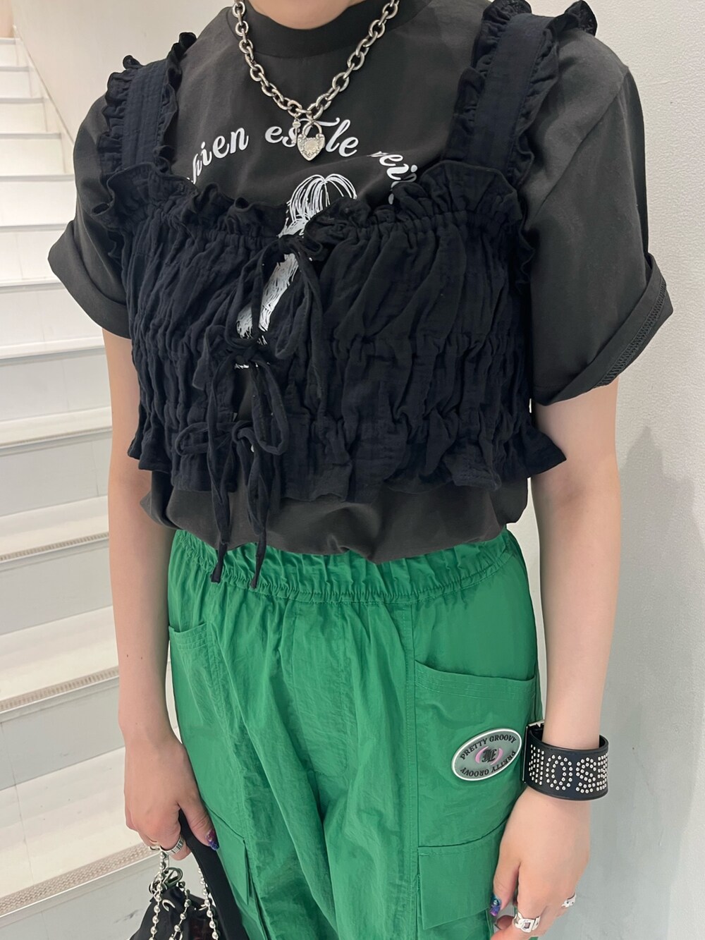 グリーン系のカーゴパンツ、ブラック系のベスト、グレー系のTシャツ/カットソーを着用したレディースの夏コーディネートの6枚目の写真